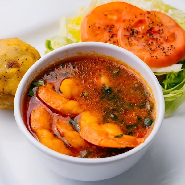 Ponce Restaurant's shrimp stew with plantain and a side salad with sliced tomatoes.