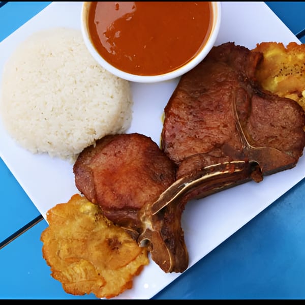 Ponce Restaurant's Puerto Rican dish with rice, fried plantains, and two cuts of meat with sauce.