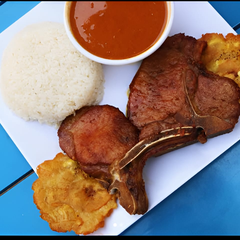 Ponce Restaurant's Puerto Rican dish with rice, fried plantains, and two cuts of meat with sauce.